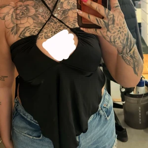 Halterneck topp NAKD - En svart halterneck topp från NAKD. I mjukt och otroligt stretchigt material. OBS det är ingen fläck på tröjan, endast på spegeln där jag tog bilden. Normal i storlek men iochmed att den är så stretchig skulle jag säga att den passar mellan M-XL 