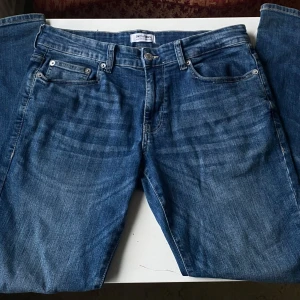 Blå jeans från Only & Sons - Snygga blå jeans från Only & Sons med klassisk femficksdesign och knappgylf. Jeansen har en normal pass form. Tillverkade i slitstarkt denim som ger en tidlös look. Storleken är W31 L30