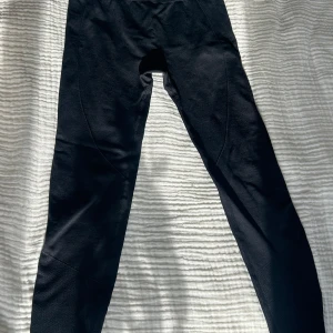 Svarta leggings - Snygga svarta leggings i ett stretchigt material. Perfekta för både träning och vardag. De har en tight passform och är högmidjade för extra komfort. Materialet är mjukt och följsamt.