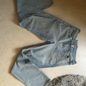 Blå jeansbyxor - Säljer ett par klassiska blå jeansbyxor med normal passform. De har en traditionell femficksdesign och knappgylf. Perfekta för en avslappnad stil. De e regular fit 