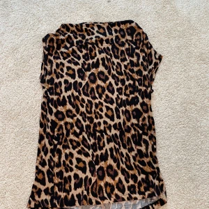 Leopardmönstrad topp från Label Collection lager 157 - Säljer en snygg leopardmönstrad topp från Label Collection lager 157. Toppen har en normal passform och korta ärmar, perfekt för att ge en djärv touch till din outfit. 🐆