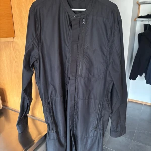 Overshirt/parka Stone Island - Säljer en stilren svart jacka från Stone Island. Jackan har en dragkedja framtill och flera praktiska fickor. Den är långärmad och tillverkad i ett syntetmaterial, perfekt för höst och vår. Enkla detaljer ger den en modern look. Givetvis äkta . Kan scannas 
