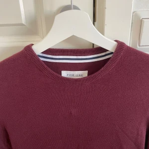 Vinröd tröja från Pier One - Snygg vinröd tröja från Pier One med rund halsringning. Perfekt för kyligare dagar med sin stilrena design. Passar både till vardags och mer uppklädda tillfällen.