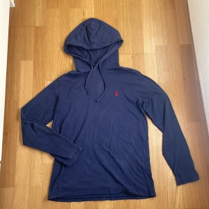Mörkblå hoodie från Ralph Lauren - Hej, säljer denna lite tunnare ÄKTA Ralph lauren hoodien som är perfekt för det varma sommarvädret. Hoodien har inga defekter och är som ny, den är använd varsamt och endast ett fåtal gånger. Storlek S men passar medium. Nypris är 1500kr