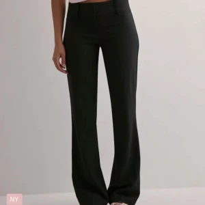 Svarta kostymbyxor - Snygga svarta kostymbyxor med låg midja och en elegant bootcut-stil. Perfekta för en stilren look. Byxorna har en klassisk design med en smickrande passform. Inprincip nya då jag använt de en gång💕💕