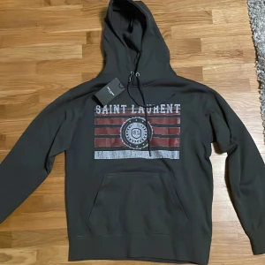 Mörkgrå  Saint Laurent hopdie M passar S - Mörk grå Saint Laurent hoodie i storlek M men passar S. nyskick. 