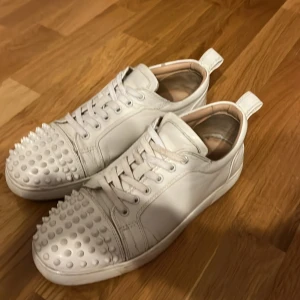 Vita sneakers med nitar - Snygga vita sneakers med coola nitar på tån. Skorna har snörning och en rund tå. Perfekta för att ge din outfit en edgy touch.
