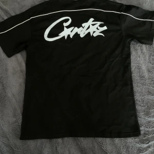 Svart t-shirt från Corteiz - Säljer en svart t-shirt från Corteiz med vit text på bröstet och ryggen. T-shirten är kortärmad och tillverkad i 100% bomull. Perfekt för en avslappnad stil. Perfekt för sommarn🕶️⛱️. Den är använd. Den är True to size, så den passar för S. 