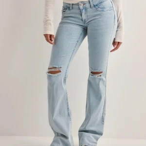 Ljusblå bootcut jeans - Snygga ljusblå bootcut jeans med slitningar på knäna som är populära! Kan inte tänka mig gå ner pris då de bara har använts minst fem gånger!