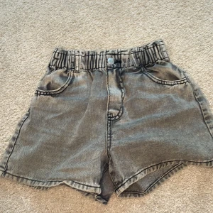 Grå jeansshorts från H&M - Säljer ett par grå jeansshorts från H&M med elastisk midja och fickor både fram och bak. Perfekta för en avslappnad stil. 🩳 stretchiga !!