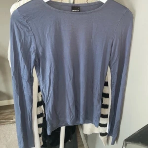 Långärmad med slits  - En blå långärmad tröja från Gina tricot i storlek S. Materialet är mjukt och bekvämt. Den har en slits vid ärmslutet.