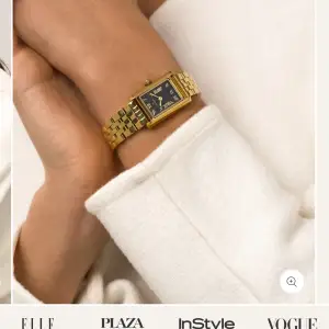 Elegant guldfärgad klocka från Mockberg med svart urtavla och romerska siffror. Klockan har en rektangulär boett och en länkarmband i guld. Perfekt för att ge en lyxig touch till din stil. Klockan är i bra skick men har en liten repa på skärmen inget man tänker på men där av det billiga priset. Fråga gärna om bilder