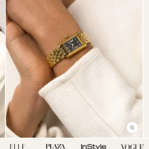 Guldfärgad klocka från Mockberg - Elegant guldfärgad klocka från Mockberg med svart urtavla och romerska siffror. Klockan har en rektangulär boett och en länkarmband i guld. Perfekt för att ge en lyxig touch till din stil. Klockan är i bra skick men har en liten repa på skärmen inget man tänker på men där av det billiga priset. Fråga gärna om bilder