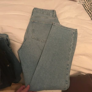 Ljusblå jeansbyxor - Säljer ett par klassiska ljusblå jeansbyxor med hög midja. De har en fin passform och är tillverkade i ett slitstarkt denimtyg. Perfekta för en avslappnad stil.