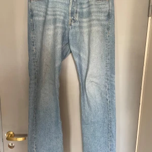 Blå jeansbyxor Relaxed/Chris - Säljer ett par ljusblå jeansbyxor med en avslappnad passform. De har en klassisk design med fem fickor och knappgylf. Perfekta för en casual look.