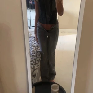 Grå jeans från Perfect Jeans - Snygga grå jeans från Perfect Jeans med en klassisk femficksdesign. De har en rak passform och är perfekta för en avslappnad stil. Jeansen har en dragkedja och knapp framtill.