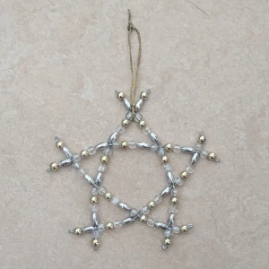 Pärlad stjärna i silver och guld - Unik stjärnformad dekoration gjord av små pärlor i silver, guld och transparent. Perfekt att hänga upp med den tunna guldtråden. Stjärnan har en cool geometrisk design och skimrar snyggt i ljuset. Passar perfekt som pynt till vintern eller julen.