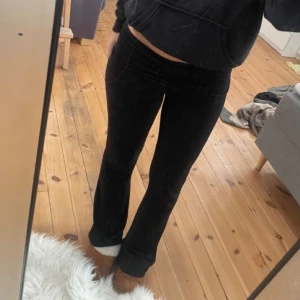 Svarta bootcut leggings - Säljer ett par svarta leggings med bootcut-snitt och låg midja. De är stretchiga och sitter tajt upptill men släpper ut vid anklarna. Perfekta för dig som gillar en bekväm men ändå trendig look.