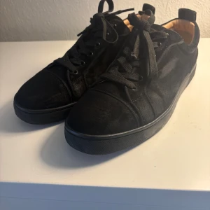 Svarta sneakers från Louboutin - svarta sneakers från Christian Louboutin i mocka med klassiska röda sulor.