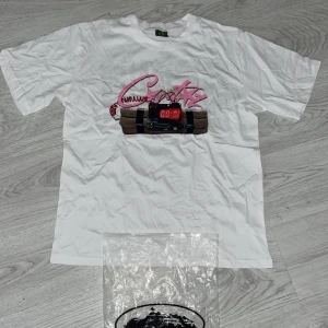 Vit t-shirt Corteiz No Time 4 Luv - Vit t-shirt från Corteiz i storlek Large med tryck framtill av en bomb med digital timer och rosa graffiti-text. Baksidan har fet svart text 'NO TIME 4 LUV'. Klassisk rund hals och korta ärmar, gjord i mjuk bomull. Perfekt statement-plagg för dig som gillar edgy stil. Hör av er vid intresse eller frågor ❤️🎉🚌‼️‼️✅💞