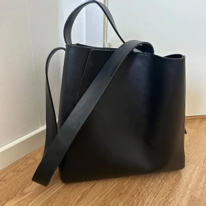 Svart axelväska i skinn - Stilren svart axelväska i slätt skinn med minimalistisk design. 💞💞