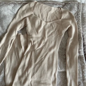 Stickad klänning  - Super fin beige stickad klänning med tajt passform! Fina detaljer på framsidan och även en slits baktill. Är Stretchig i materialet skulle säga passar S-M. Hör av er vid flera frågor.