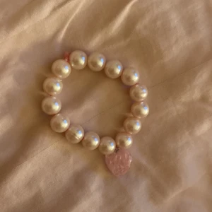 Pärlarmband med rosa hjärthänge - Superfint armband med stora ljus rosa pärlor och ett glittrigt rosa hjärta. Egen gjort armband!