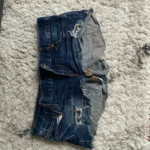 Blå lowwaist mini jeansshorts med slitningar - Snygga low waist mini jeansshorts i strl 38, midja:39. Kommer fler unika jeansshorts o kjolar så följ!!