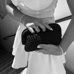 Svart handvirkad clutch - Säljer en svart handvirkad clutch / handväska som jag har virkat! Väskan är i ett mjukt garn och är väldigt rymlig! Kan bäras i handen som en clutch eller bäras i handtaget.