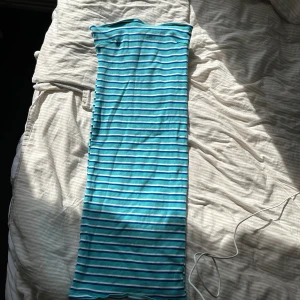 Randig blå och vit långklänning - Säljer en tub långklänning, den är väldigt stretchig och skön. Sitter som en smäck. Strl L men passar för dom som har M och S skulle jag säga, slutsåld 