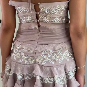 klänning med paljetter från Asos design - Helt ny superfin klänning från ASOS i storlek 40, men definitivt mer som storlek 36/38. Axelbandslös med snöring för nacken, men går att knyta på flera sätt beroende på vad man gillar. Lapparna sitter kvar och den är endast provad. Har dragkedja där bak med öppen rygg och knappar längre upp. Jätte vacker lavender/ros färg.