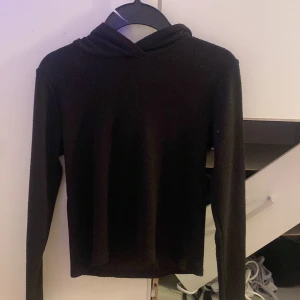 Svart stickad hoodie från Kappahl - Svart stickad hoodie från Kappahl i storlek 146/152. Tröjan har lång ärm, huva och är gjord i ett mjukt stickat material. Enkel och stilren modell som passar perfekt till höst och vinter. Snygg att matcha med jeans.