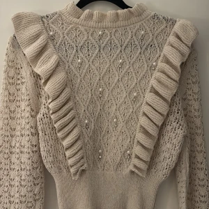 Beige stickad tröja med volanger och pärlor Zara - Supersöt beige stickad tröja från Zara med volanger och pärlor💗i mycket bra skick, storlek s!! Kontakta mig vid frågor eller funderingar💞