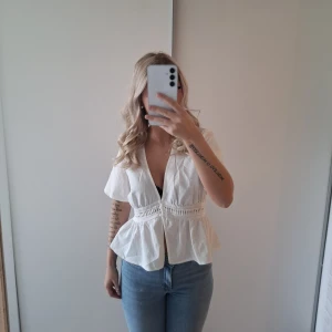 Vit blus - Säljer en vit blus med korta ärmar och v-ringad hals. Endast använd 2 gånger