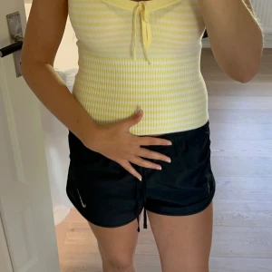 Gul och vit randig ribbad linnetopp - Superfin croppad linnetopp från Hollister x Gilly Hicks i ljusgul och vit med smala ränder. Toppen har justerbara axelband, söt knytning fram och är ribbad nedtill för extra snygg passform. Perfekt för soliga dagar.