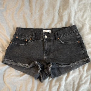 Svarta jeansshorts från Gina Tricot - Svarta jeansshorts från Gina Tricot, modell Perfect Jeans. De har råa, fransiga kanter och klassisk femficksdesign. 