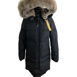 Svart dunjacka från Parajumpers - Säljer en svart dunjacka från Parajumpers med en stor pälskantad huva. Jackan har dragkedja och knappar framtill samt flera praktiska fickor. Perfekt för kalla vinterdagar.