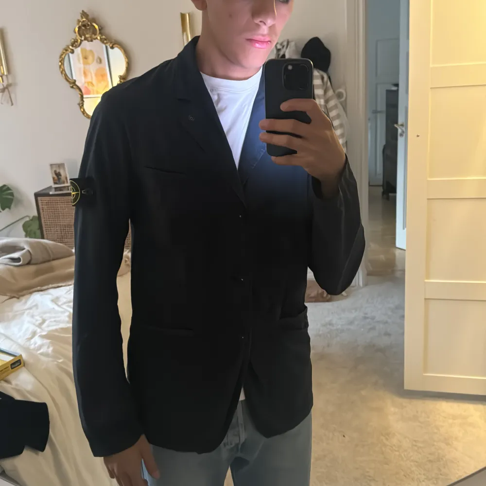 Snygg mörkblå kavaj från Stone Island med klassisk design och knappar framtill. Kavajen har en stilren look med märkets ikoniska logga på ärmen. Perfekt för en stilmedveten garderob. Perfekt Stone kavaj som funkar skit bra under sommarn . Takit.