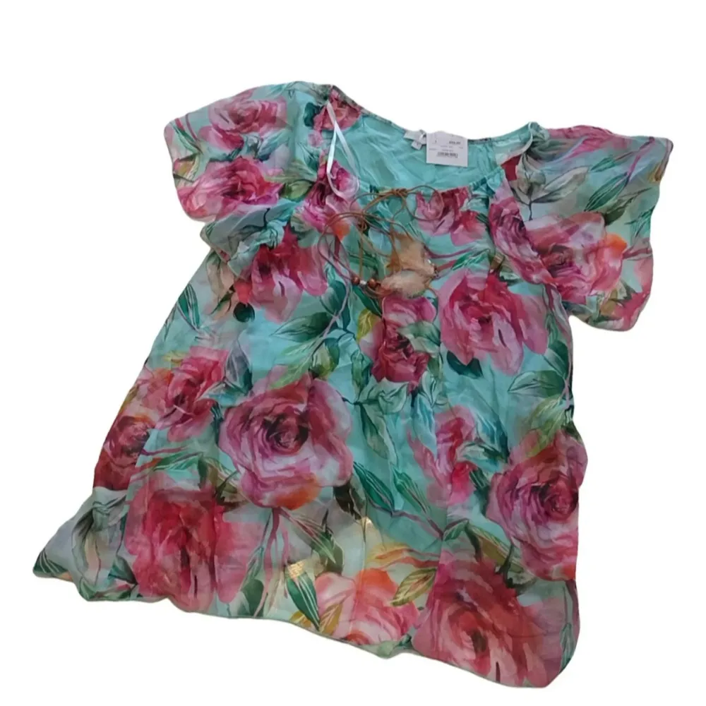 Säljer en vacker blommig klänning från Made in Italy. Blusen har ett färgglatt mönster med stora blommor i rosa och gröna nyanser. Den är tillverkad av en blandning av viskos och siden, vilket ger ett lyxigt och luftigt intryck. Perfekt för sommarens alla tillfällen! Storleken 1, men blusen är mellan S och M i verkligheten, sitter väldigt löst.. Puserot.