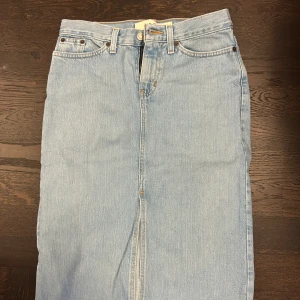 Ljusblå jeanskjol  - Säljer en snygg ljusblå midi jeanskjol från GAP. Tillverkad i 100% bomull för en bekväm passform. I mycket bra skick. Osäker om exakt storlek men passar XS eller S. Kontakta mig om fler blider önskas.💛