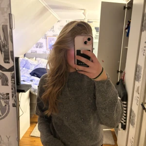 Grå stickad tröja - Säljer en mysig grå stickad tröja med långa ärmar. Perfekt för kyligare dagar och passar till många olika stilar. Tröjan har en enkel och stilren design.