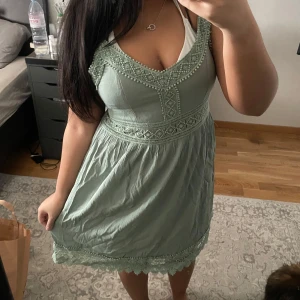 Grön klänning med spetsdetaljer - Spetsdetaljer och justerbara axelband. Aldrig använd ute. Köpt i Turkiet.