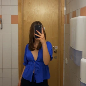 Blå blus från Gina Tricot - Säljer en snygg blå blus från Gina Tricot. Den har en v-ringad design med knytning framtill och puffiga ärmar. Så himla fin färg och somrig. 💙