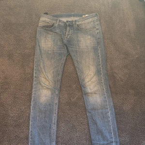Blå Dondup jeans - Säljer ett par klassiska blå dondup george jeans med en normal passform. De har en traditionell femficksdesign och en dragkedja. Perfekta för en avslappnad stil.