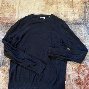 Svart tröja från Jack & Jones - Säljer en stilren svart tröja från Jack & Jones. Tröjan är långärmad och har en klassisk rund halsringning. Perfekt för en enkel och snygg look. Stickad tunn tröja. 