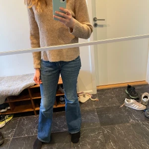 Beige stickad tröja från Carin Wester - Säljer en fin beige stickad tröja från Carin Wester. Tröjan har ett ribbat mönster och långa ärmar, perfekt för lite kyligare dagar nu på våren. Den är i storlek S och passar utmärkt till både jeans och kjol. 30% alpacka, 21%ull, 37%polyamid, 7% akryl och 5% elastan