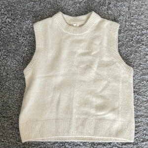 Beige stickad väst - Säljer en stilren beige stickad väst med ribbade kanter från Arket. Perfekt för både sommar och vinter. Använd ett fåtal gånger.                                                                  Köparen står för frakten💕💕  