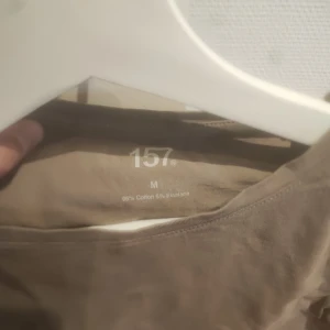 Beige croppad topp från 157 - Säljer en beige croppad topp från 157. Toppen är kortärmad och tillverkad i en mjuk bomullsblandning med elastan för extra stretch. Perfekt för en avslappnad stil.