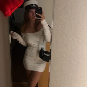 Studentklänning - Snygg vit klänning med tight passform. Klänningen har långa ärmar och en öppen rygg. Perfekt för speciella tillfällen. Exempelvis student eller liknanden. Helt oanvänd då jag valde en annan till studenten och nu är denna lite för liten för mig. Storlek 40. 