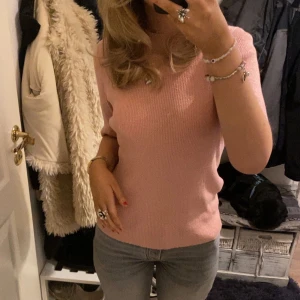 Rosa glittrig topp - Säljer en söt rosa topp med glittrande effekt. Toppen har korta ärmar och en rund halsringning. Perfekt för att lägga till lite glitter i vardagen. Passar bra till jeans eller kjol.